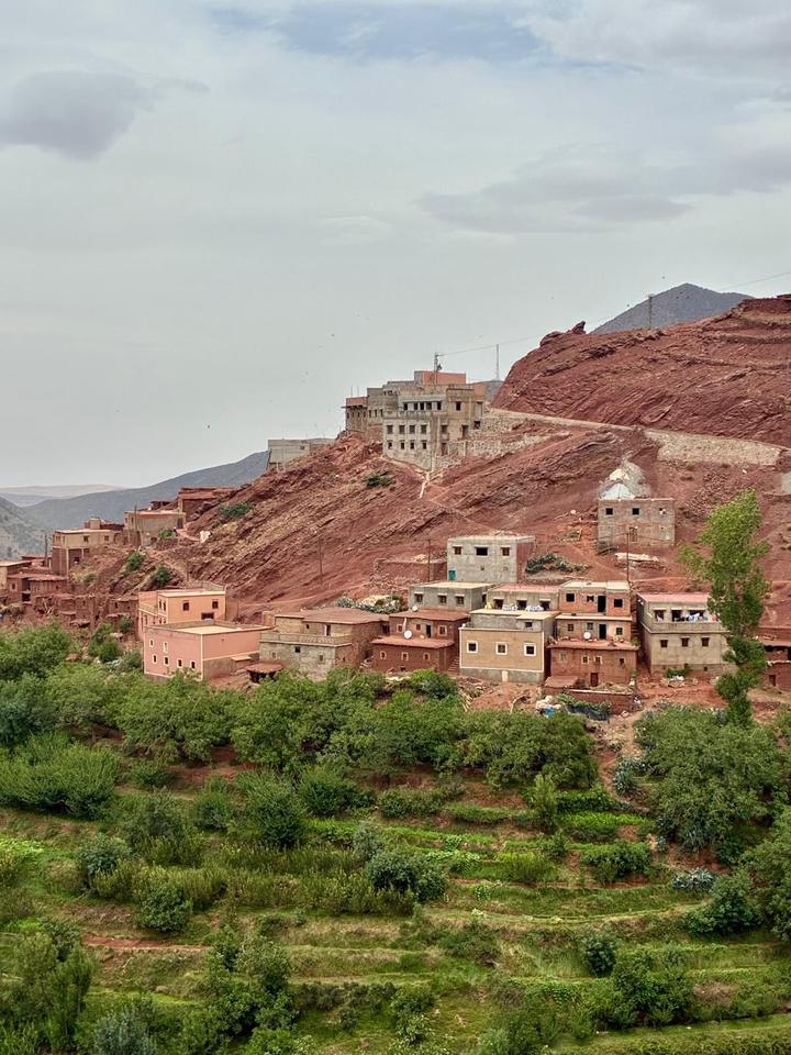 Red-earth village houses above green terraced fields