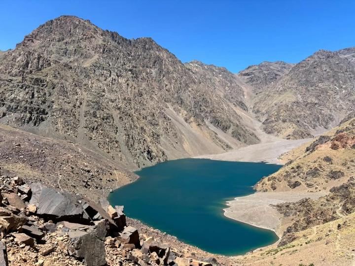 A deep blue mountain lake below rocky peaks