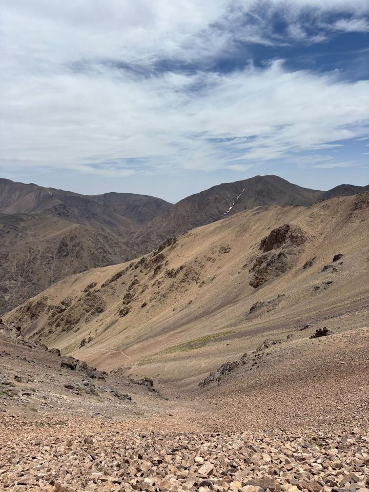 Bare golden slopes and a snow streak on a high mountain ridge