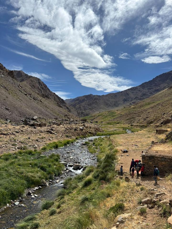 A clear mountain stream running through a green valley